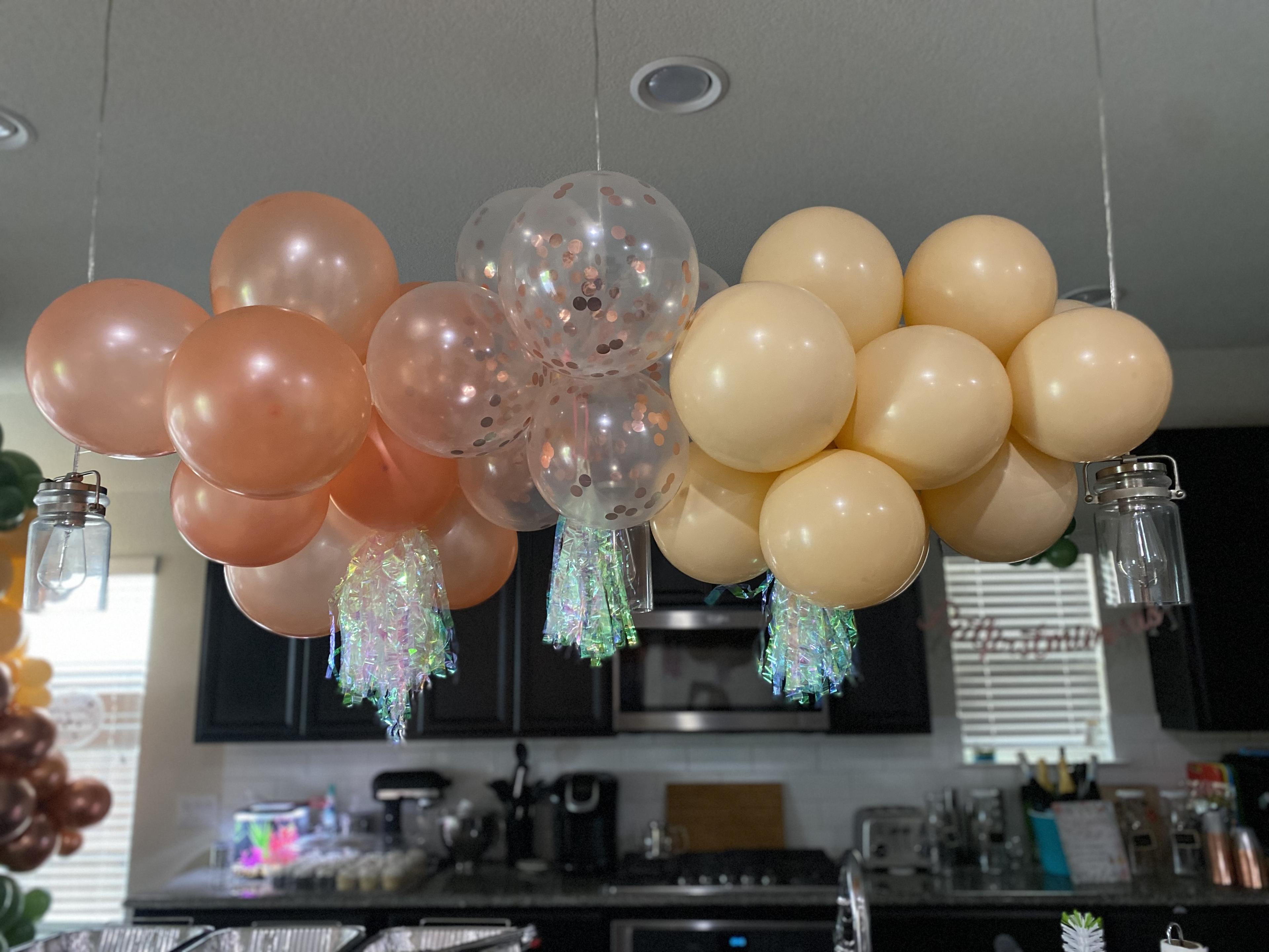 Multi-colored balloon cluster hanging from sconces